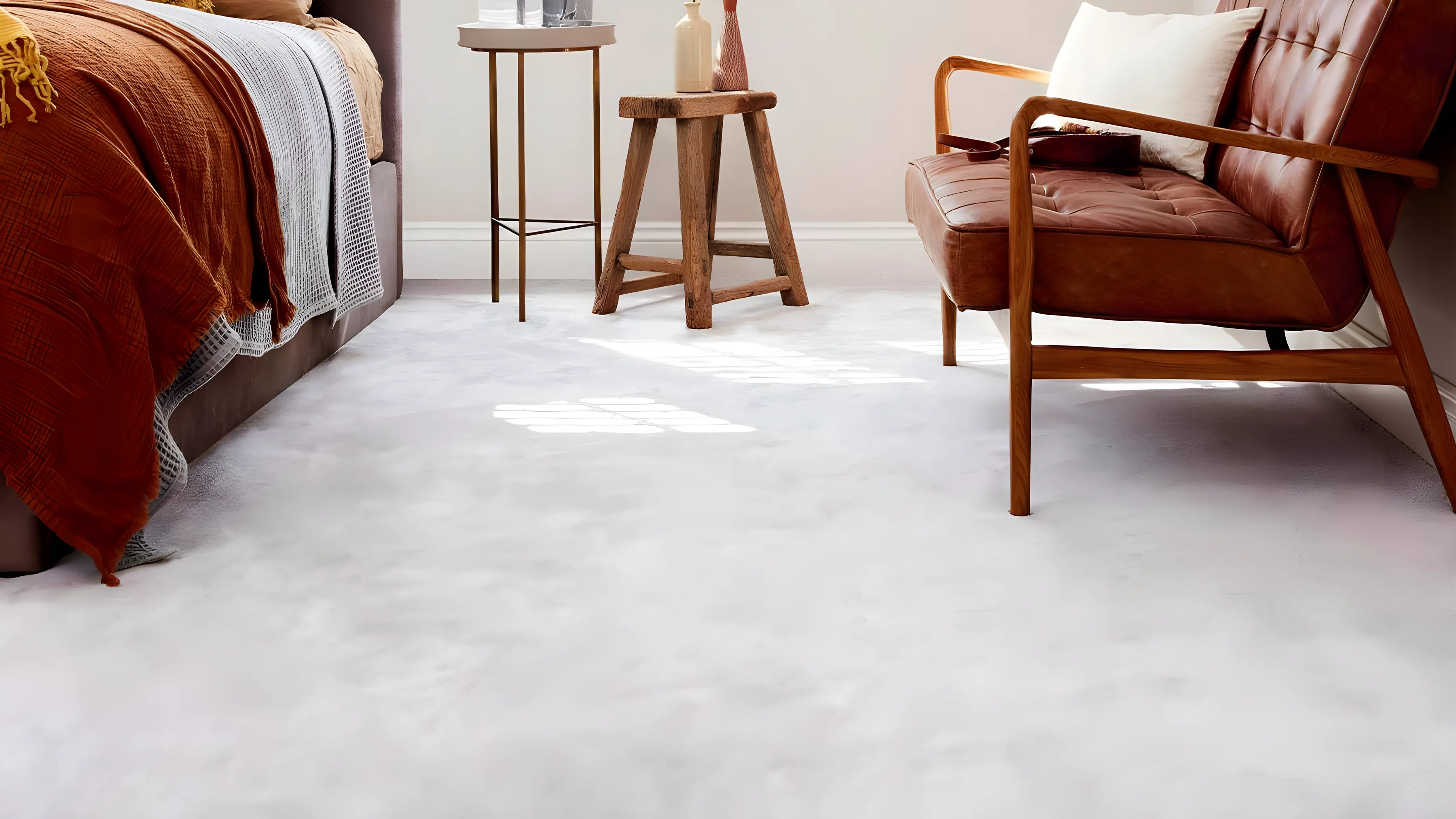 A bedroom with a deep pile carpet, a leather chair and an orange throw