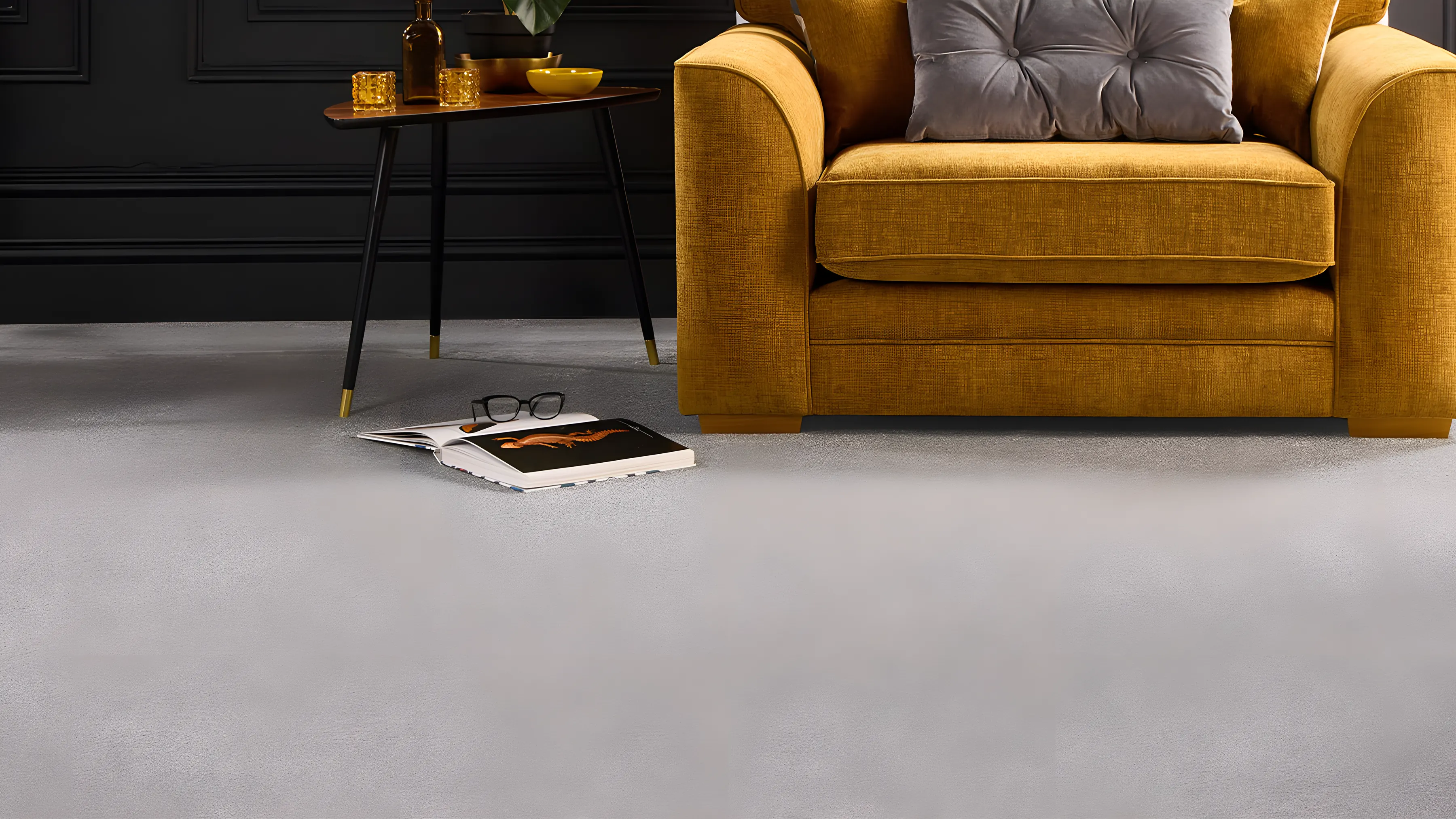 A soft grey carpet in a room with a dark wall and a mustard armchair