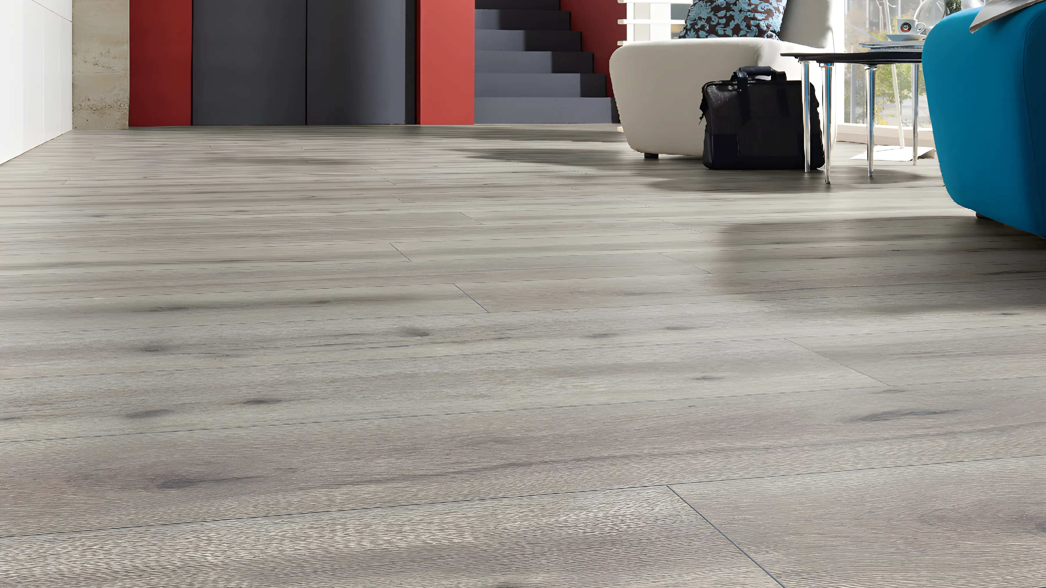 Grey plank flooring through a communal lobby with a red lift wall